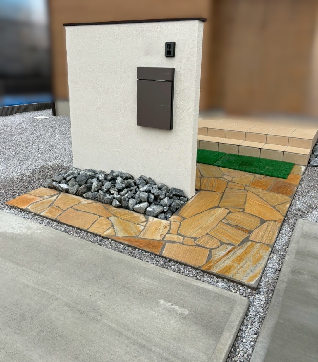 施工後　門塀　笠木　LIXIL　コーピング　色：クリエダーク／宅配ボックス　ユニソン　ヴィコDB100　色：メタルブラウン／乱形石　メイクランド　エルドラドクォーツ　色：イエロー